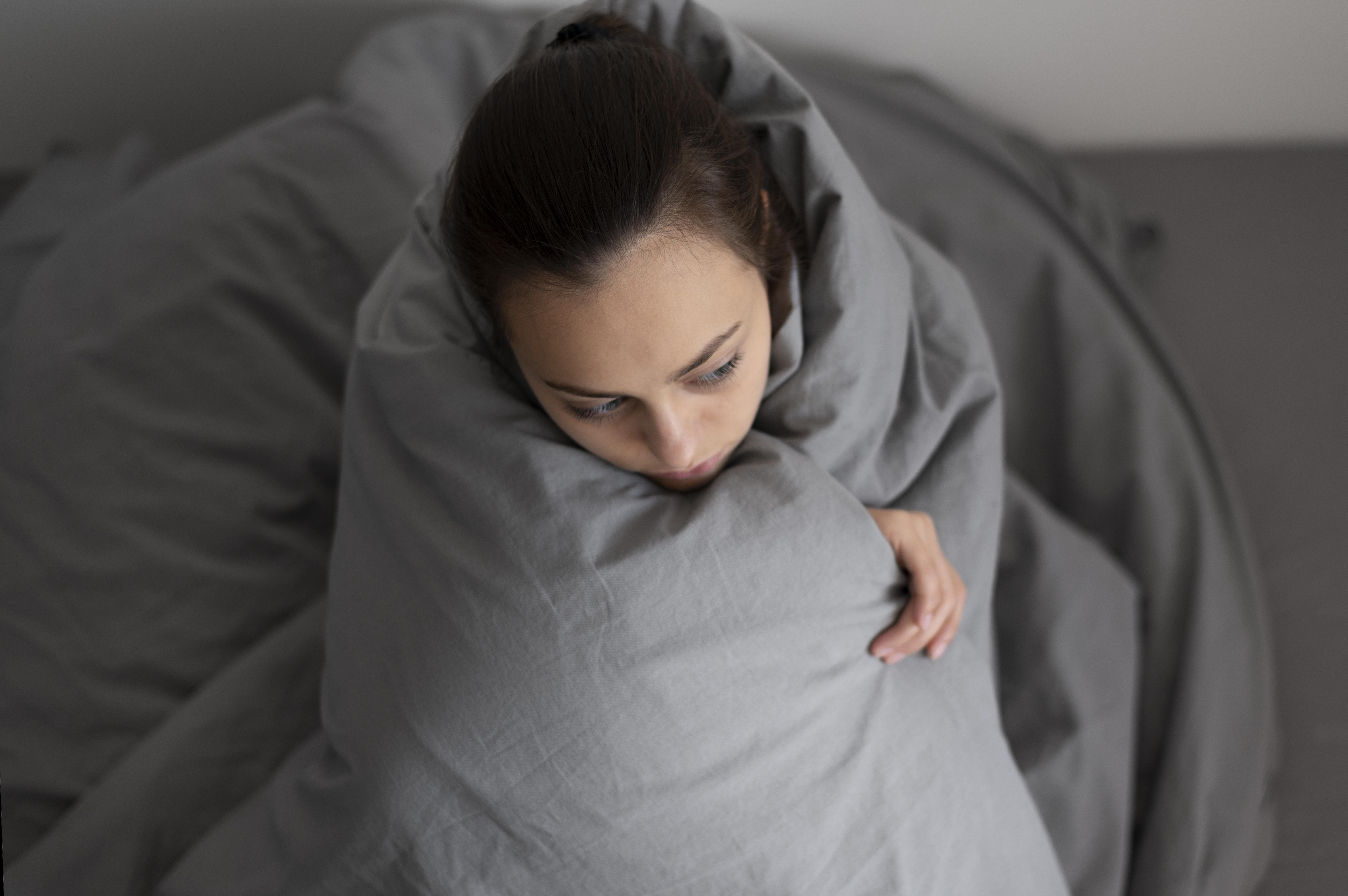 Mujer despierta en la cama en un momento de malestar y dificultad para descansar